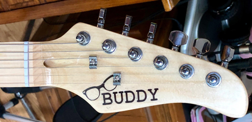 Buddy Holly's distinct black frames adorn the headstock.